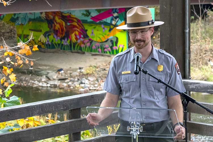 River Ranger Ryan Ainger speaks at the mural's unveiling